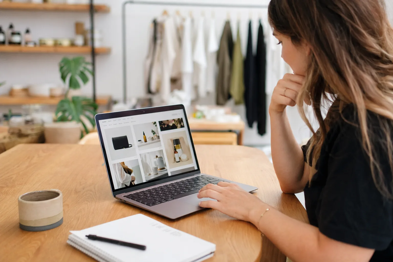 Small business owner comparing an online store layout on a laptop and phone, reflecting the process of choosing a Shopify theme that works across devices